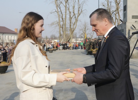 Jono Basanavičiaus gimnazijos mokinė Ugnė Šidlauskaitė įteikia „Signatarų trispalvę“ merui Dariui Varnui